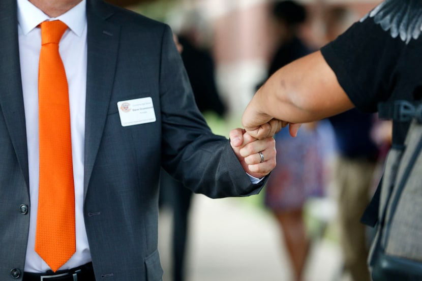 Principal Steve Drummond fist-bumps a student as they ushered in the start of a new school...