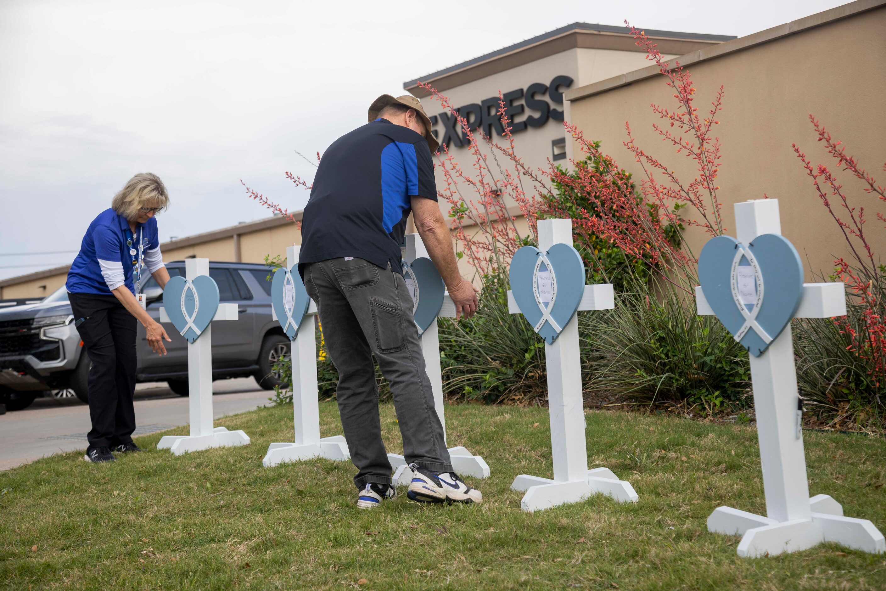 People with Lutheran Church Charities places a cross at the memorial outside the mall...