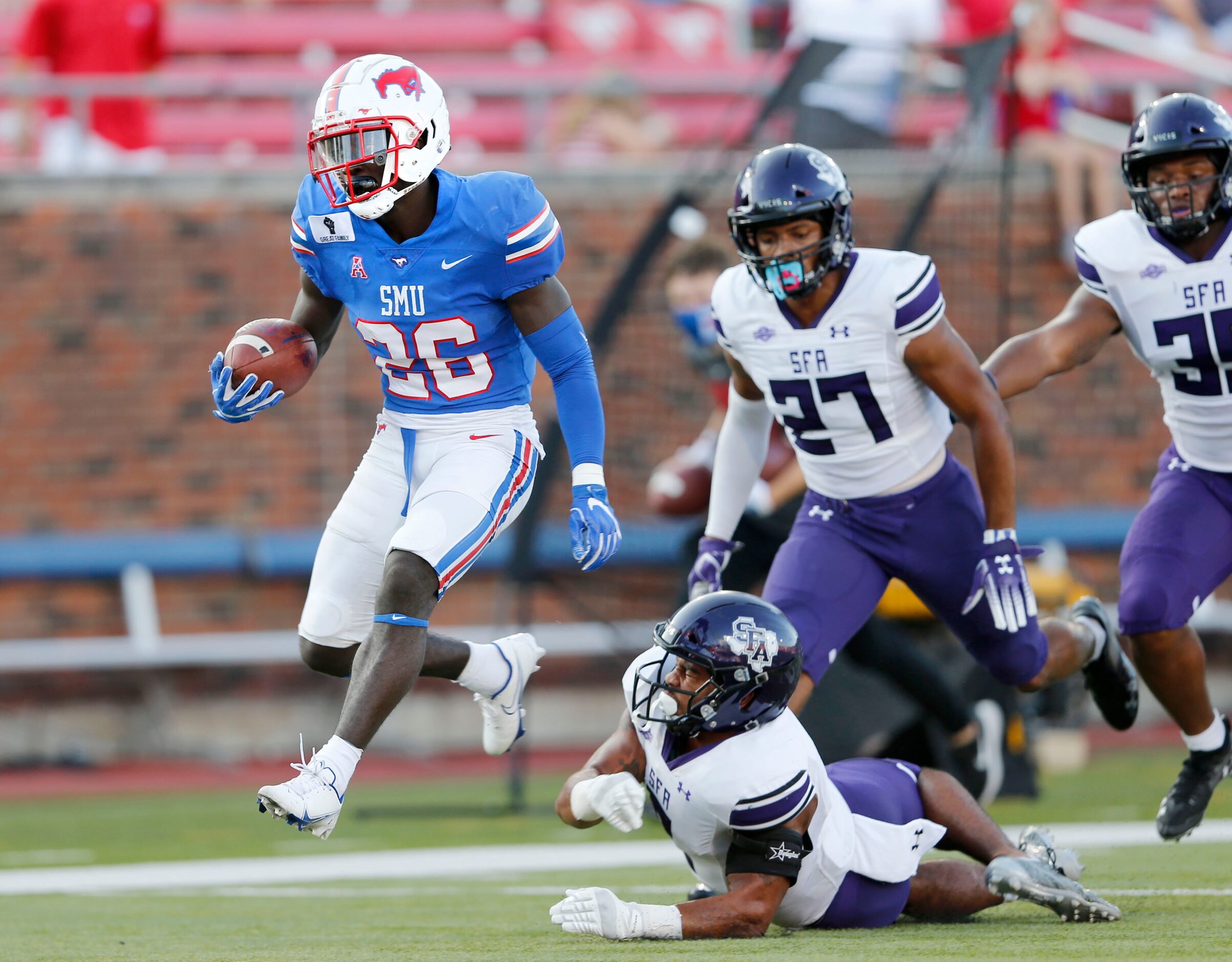 Southern Methodist Mustangs running back Ulysses Bentley IV (26) evades the grasp of Stephen...