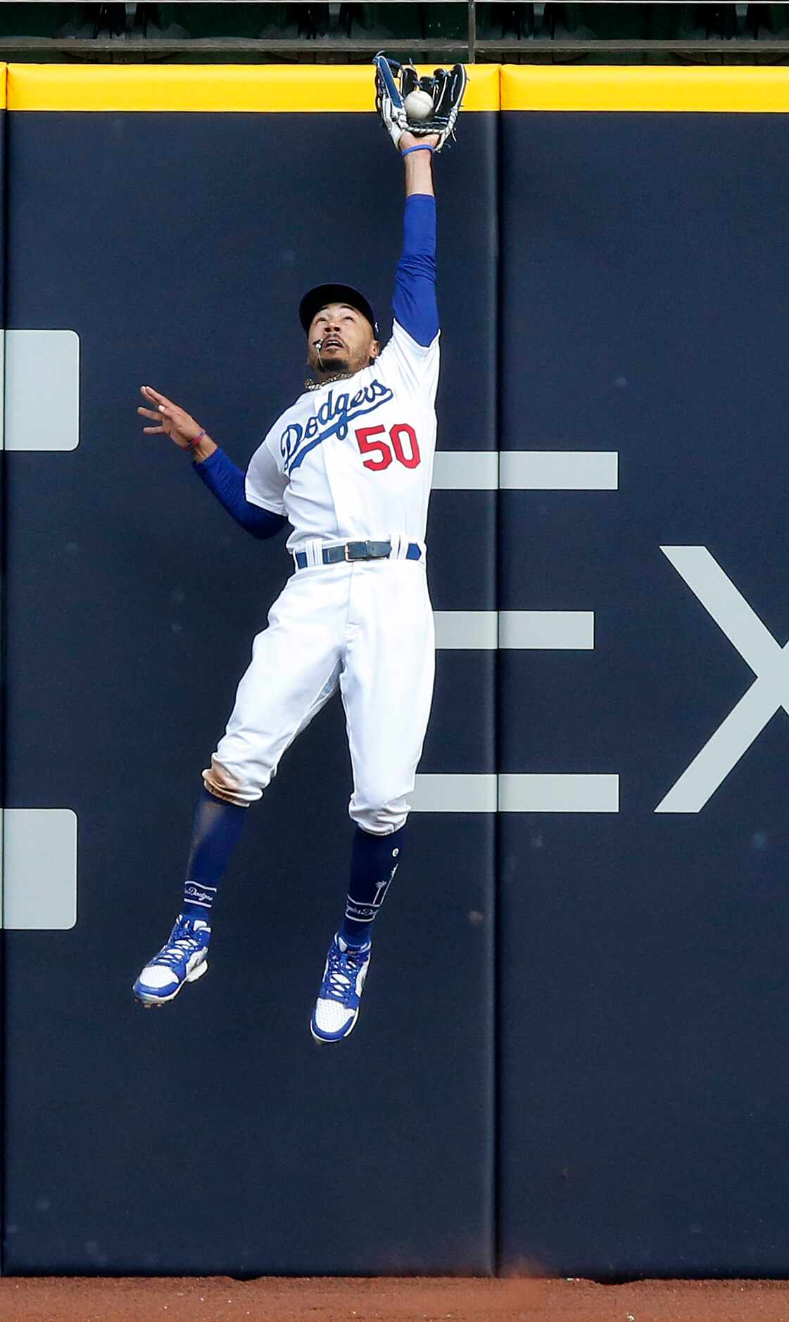 Los Angeles Dodgers right fielder Mookie Betts (50) leaps and catches a deep ball hit by...