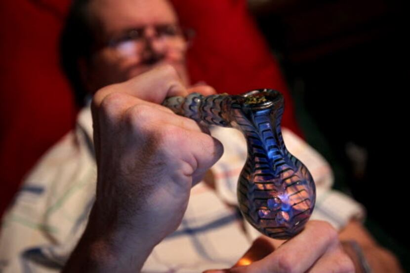  Tim Timmons holds a glass pipe filled with marijuana prior to smoking it at his Garland...