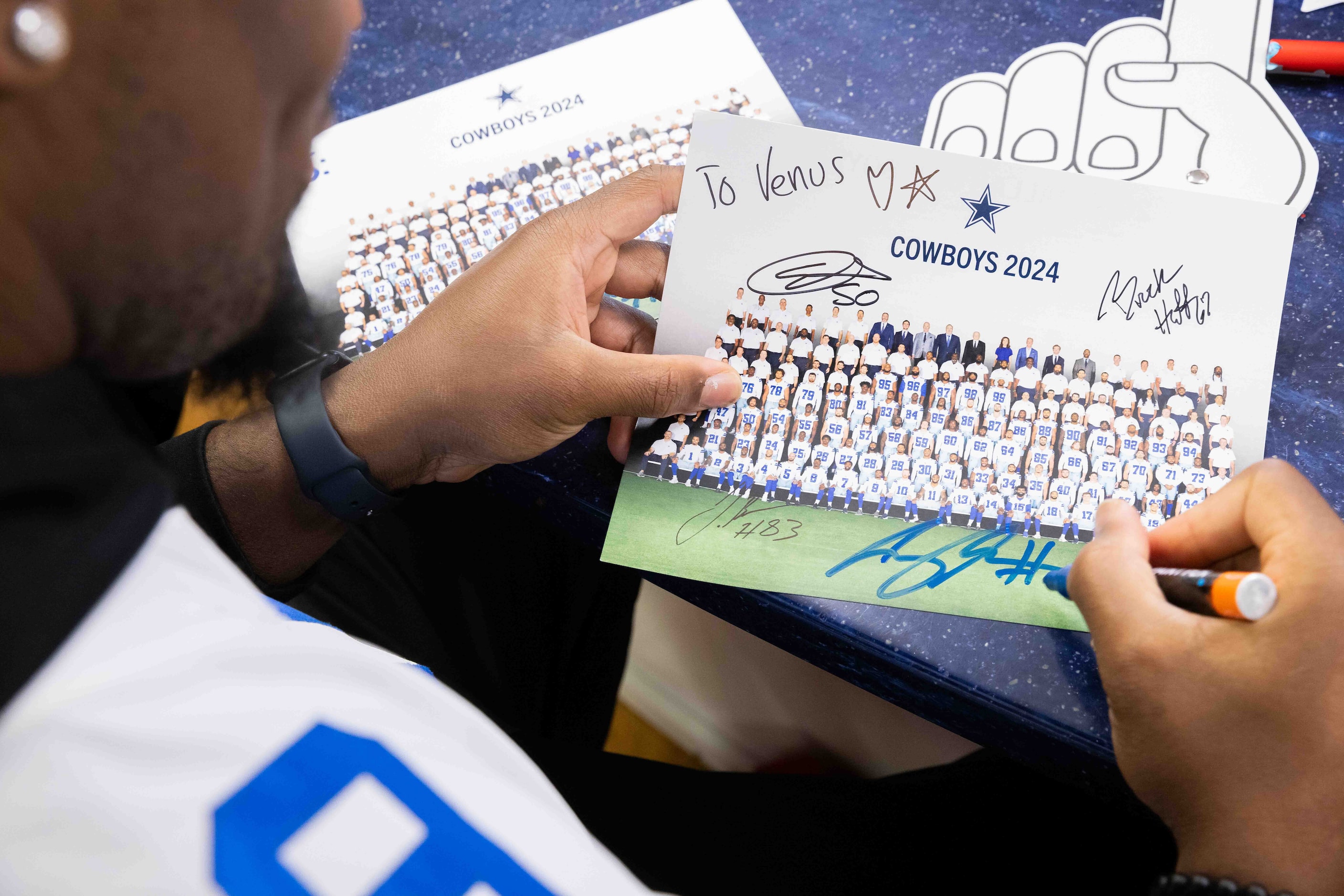 Dallas Cowboys defensive end Chauncey Golston (99) signs a photo card for Venus Garcia, 7,...