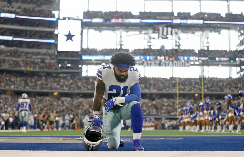 Dallas Cowboys running back Ezekiel Elliott (21) kneels in the end zone before the Green Bay...