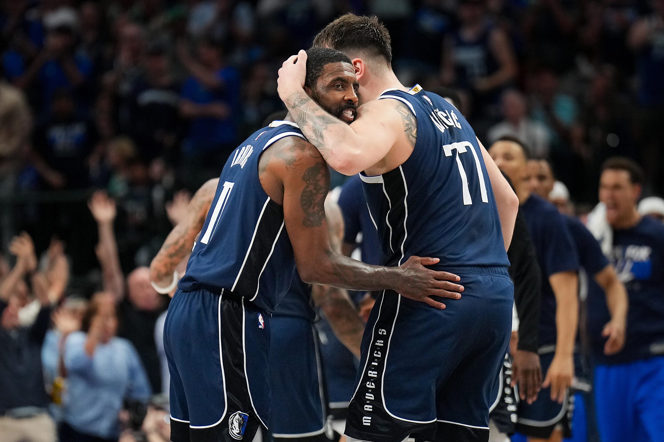 Dallas Mavericks guard Kyrie Irving (11) celebrates a basket with guard Luka Doncic (77)...