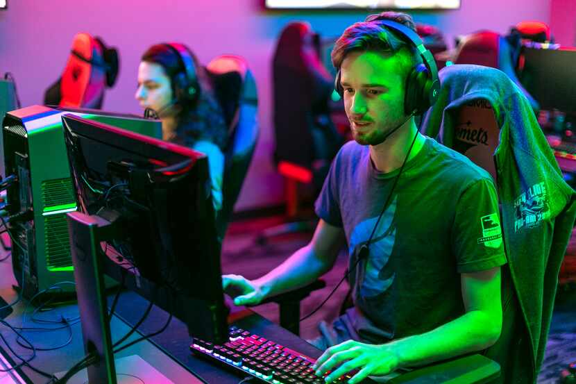 Two students on the esports team at UT Dallas sit at computers.