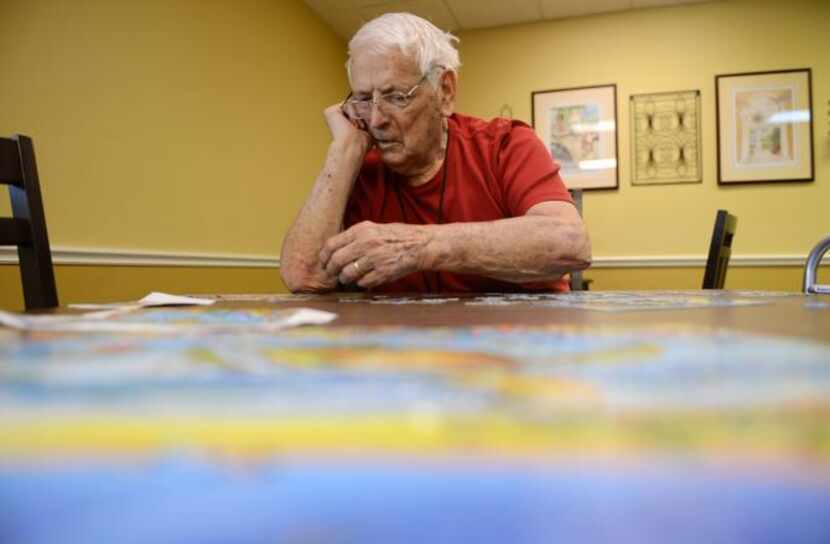 
Robert Ivory works on a puzzle at Friends Place. The Alzheimer’s Association estimates the...
