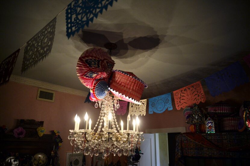 Accordion-pleated paper lanterns, called faroles, some painted with seasonal poinsettias,...