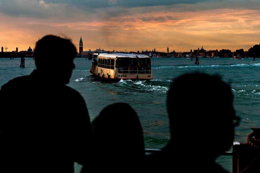 Tourists and residents board a water bus bound for Venice from the ferry terminal at the...