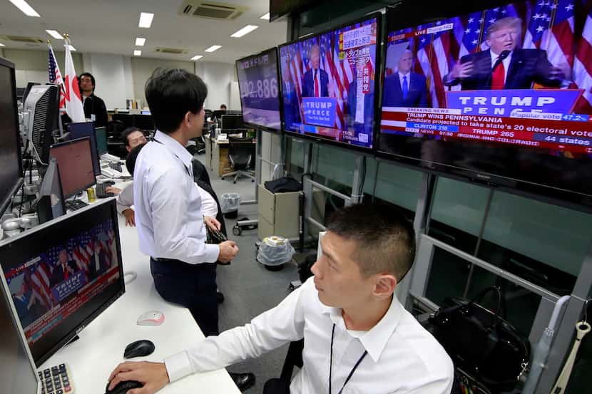 Money traders watch a news program reporting the U.S. presidential election results at a...