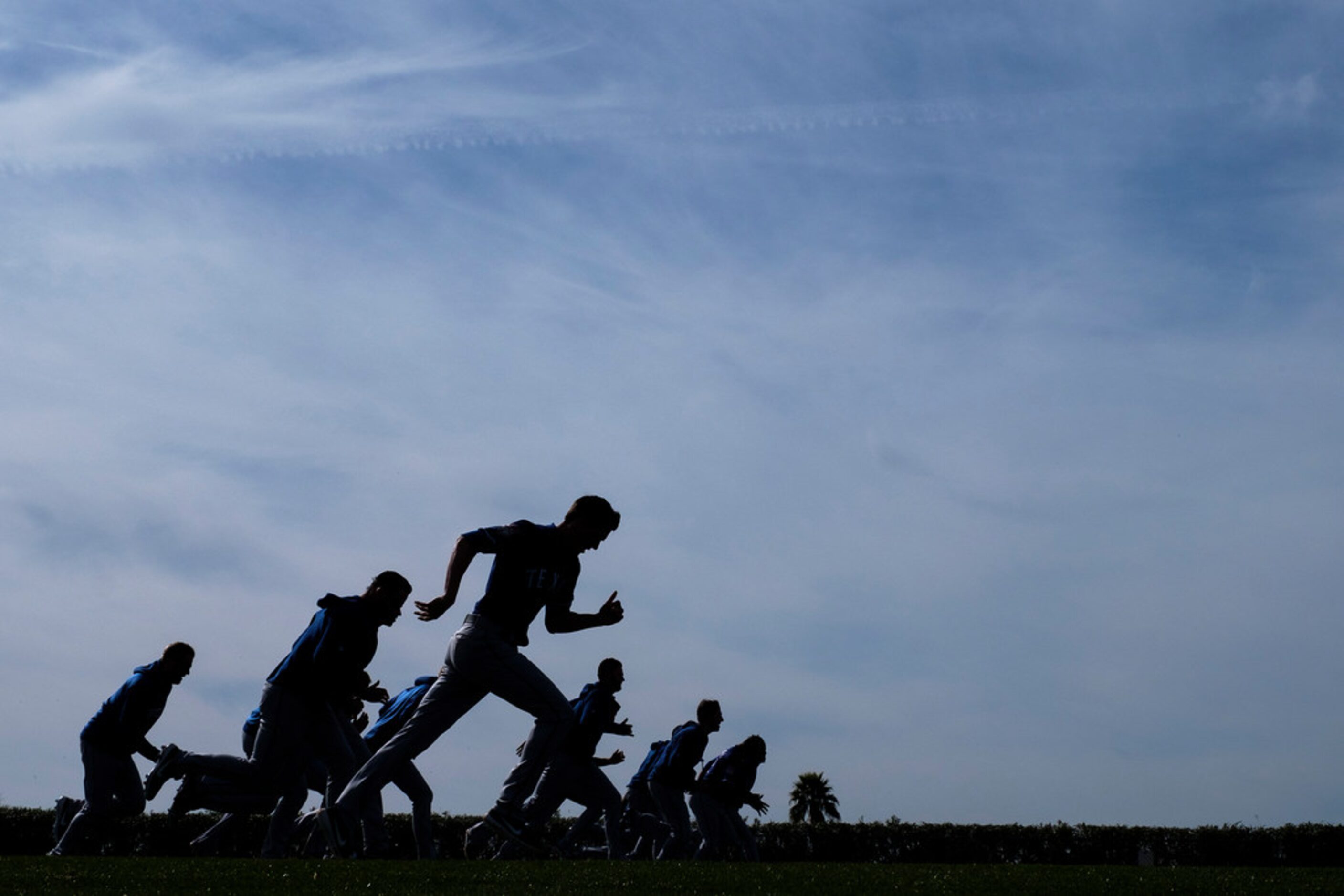 Texas Rangers pitchers run on a conditioning field during a spring training workout at the...