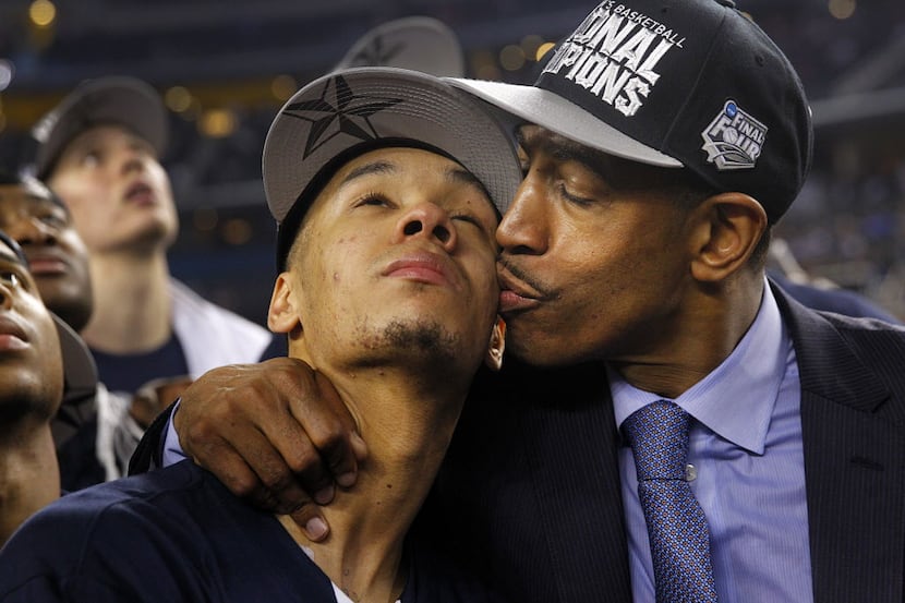 Connecticut Huskies head coach Kevin Ollie gives his star player Shabazz Napier (13) a kiss...