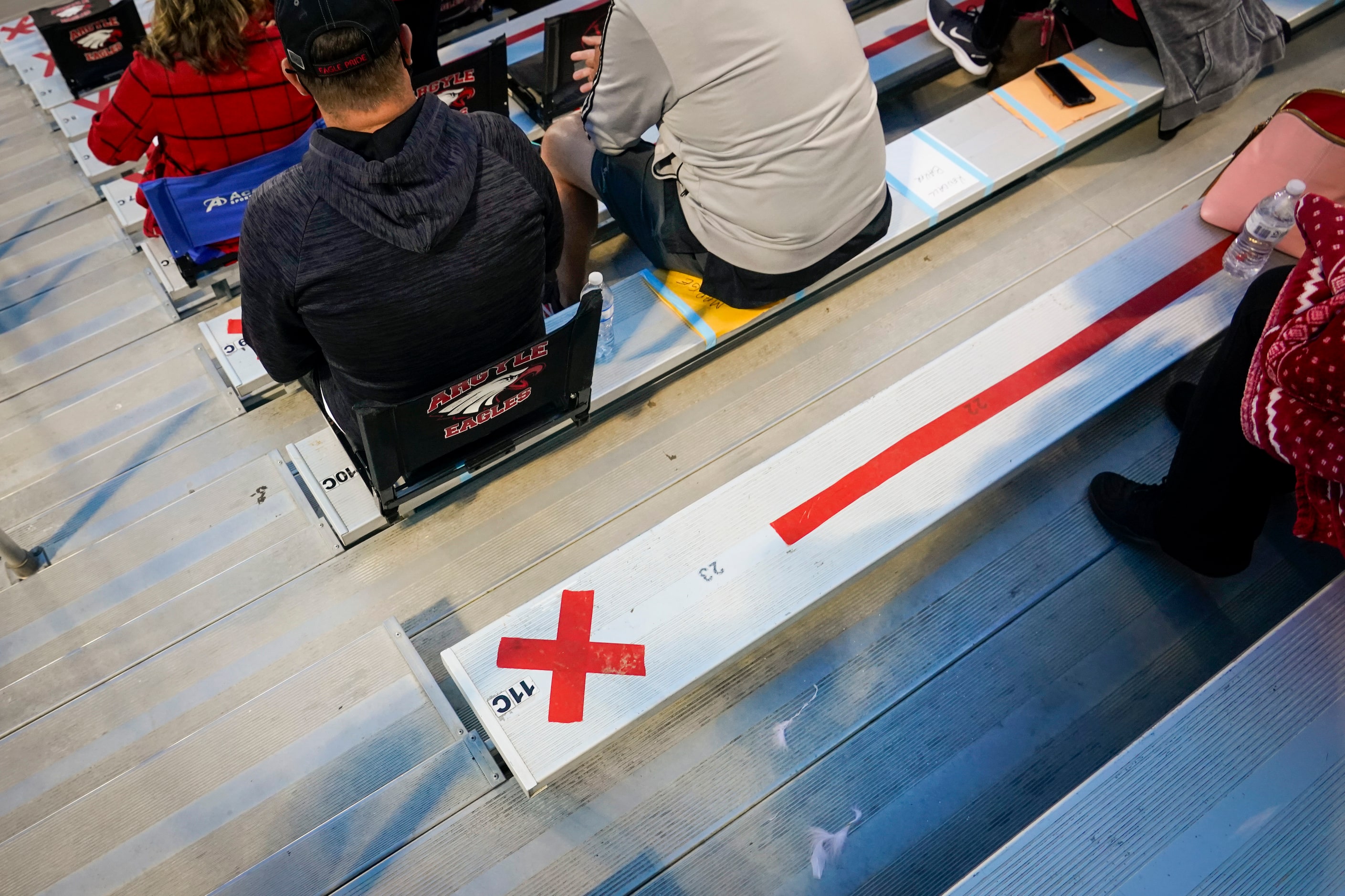 Markings in the stands block out seats for socially distancing before a high school football...