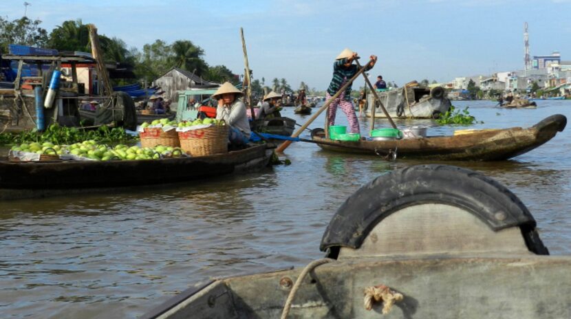 A farmer paddles his sampan through the Phong Dien retail market, an intimate retail market...