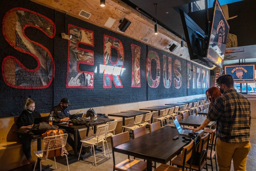 Muralist Chris Campbell painted over parts of Serious Pizza's original mural in Deep Ellum,...