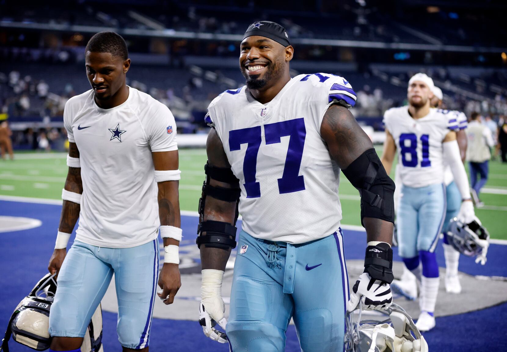 Dallas Cowboys quarterback Dak Prescott (4) alongside Tyron Smith (77)  during a Thanksgiving day NFL football game against the Las Vegas Raiders,  Thursday, Nov. 25, 2021, in Arlington, Texas. (AP Photo/Matt Patterson