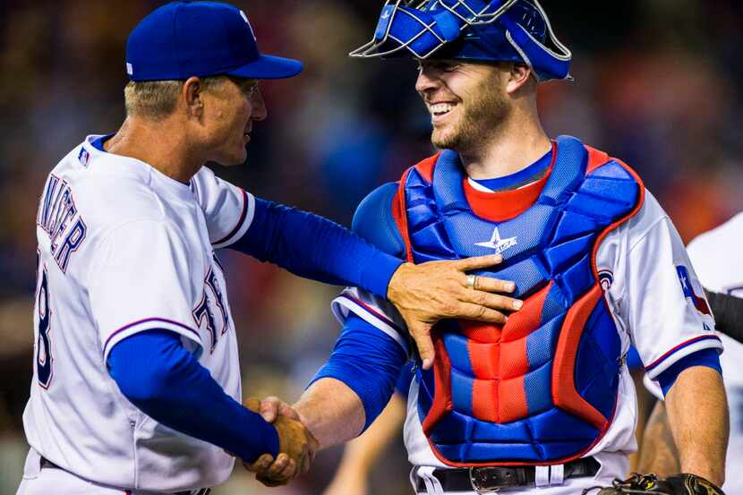 Texas Rangers manager Jeff Banister (28) shakes the hand of Texas Rangers catcher Chris...