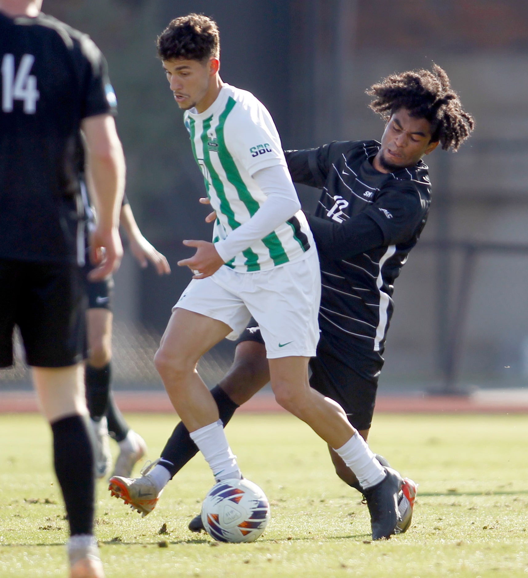 SMU Mustangs defenseman Lamar Bynum (12), right, defends against Marshall forward Lineker...