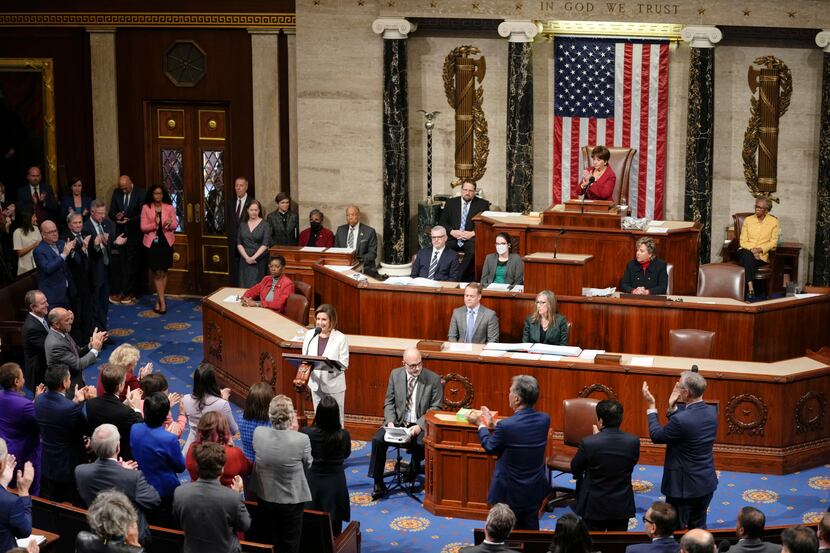 Lawmakers stand and applaud as House Speaker Nancy Pelosi of Calif., speaks on the House...