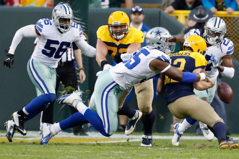 Green Bay Packers' Aaron Rodgers fumbles as he is hit by Dallas Cowboys' David Irving during...