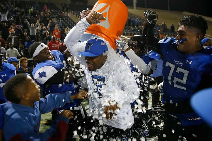 Trinity Christian-Cedar Hill coach Aveion Cason gets doused by his players after beating...