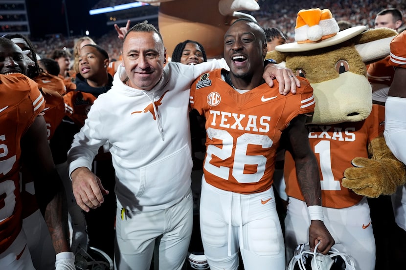 Texas head coach Steve Sarkisian celebrates with running back Quintrevion Wisner (26) after...