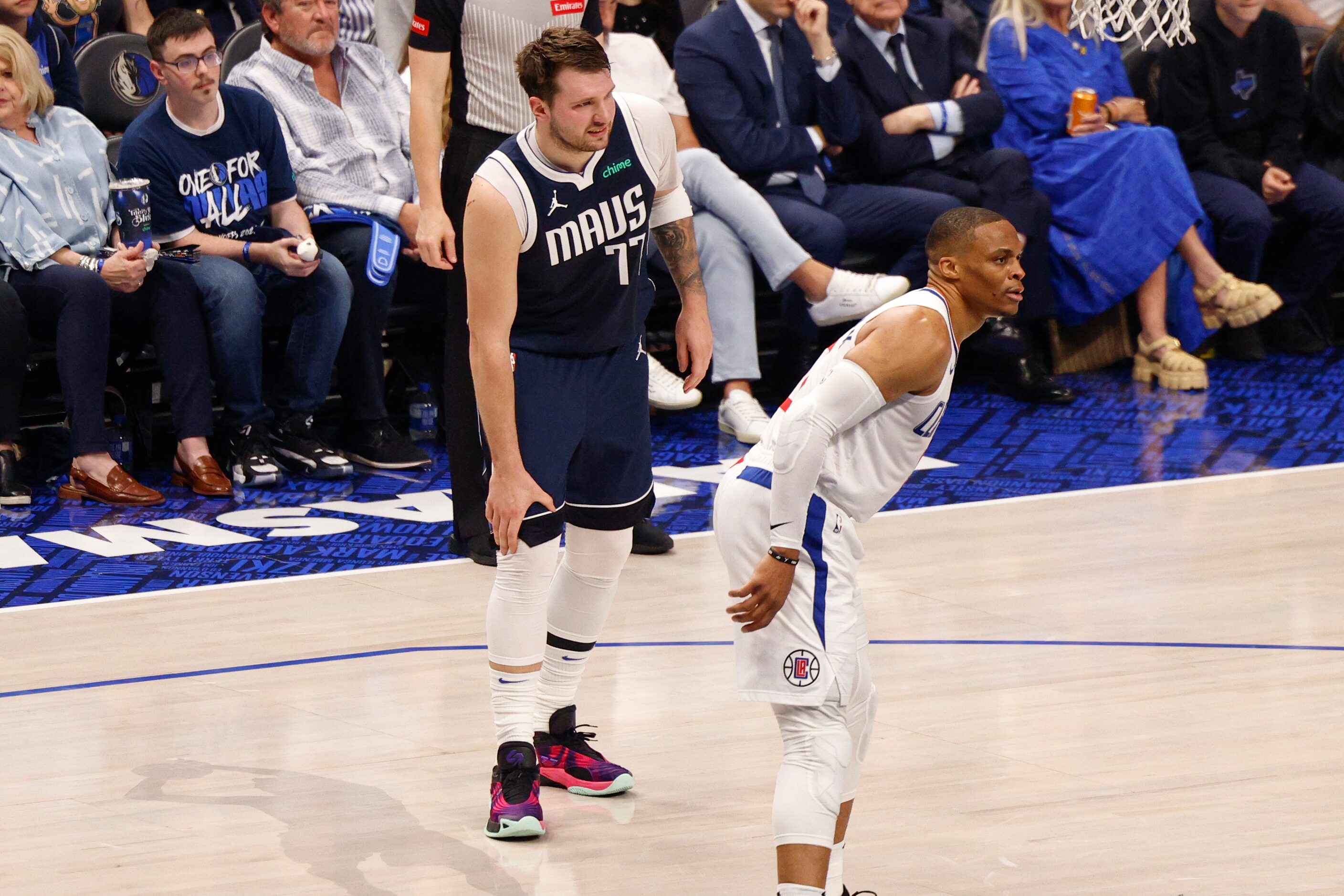 Dallas Mavericks guard Luka Doncic (77) grabs his knee after injuring it during the first...