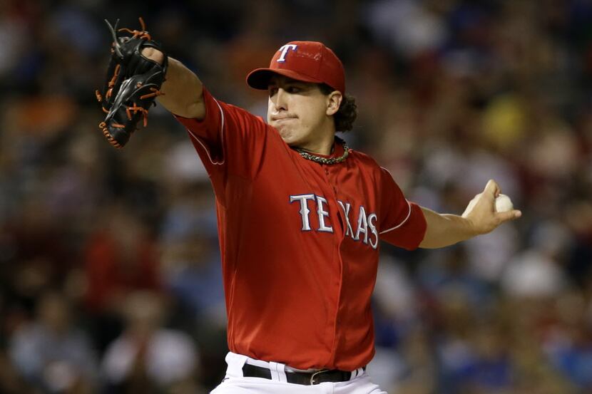 Texas Rangers starting pitcher Derek Holland works against the Houston Astros in the seventh...
