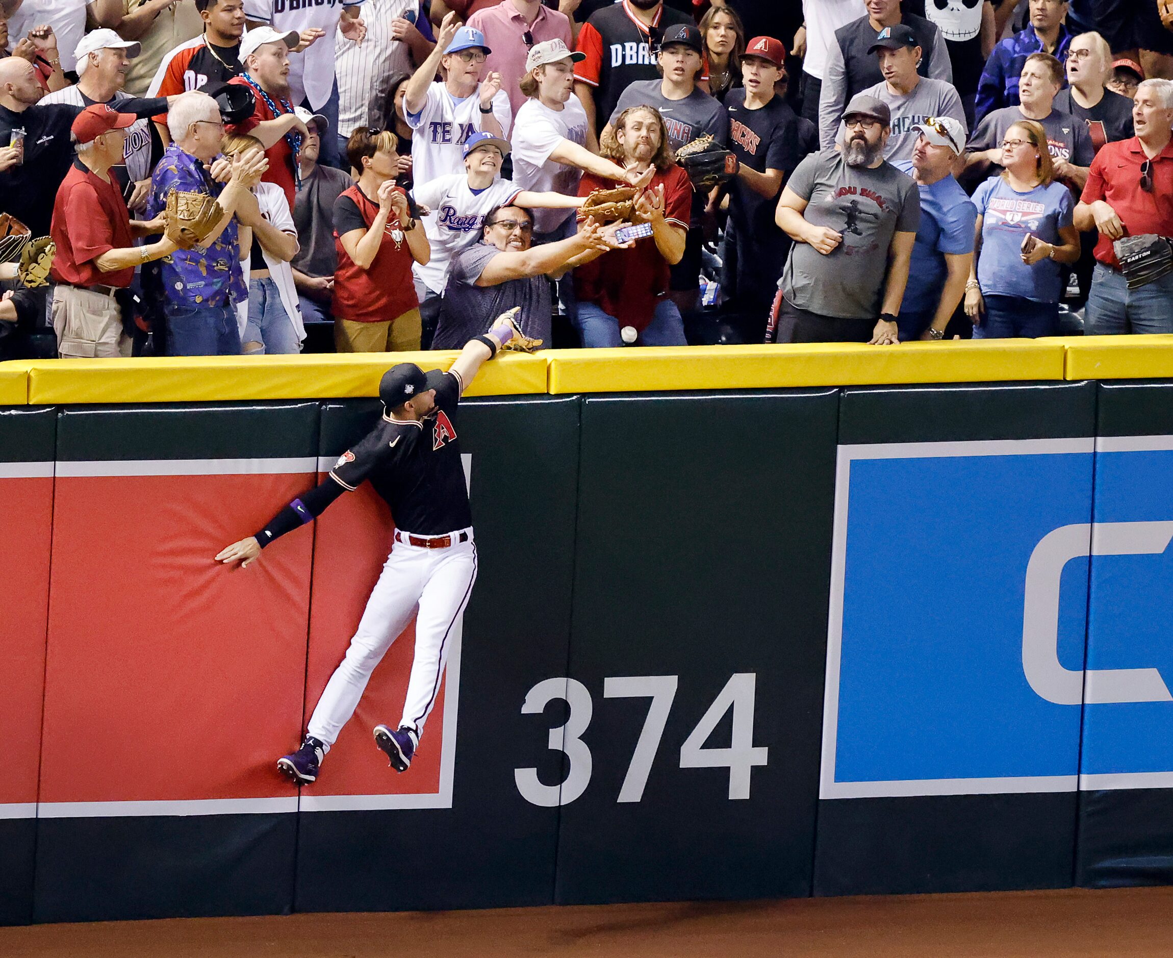 Arizona Diamondbacks left fielder Lourdes Gurriel Jr.m goes high against the wall but can’t...