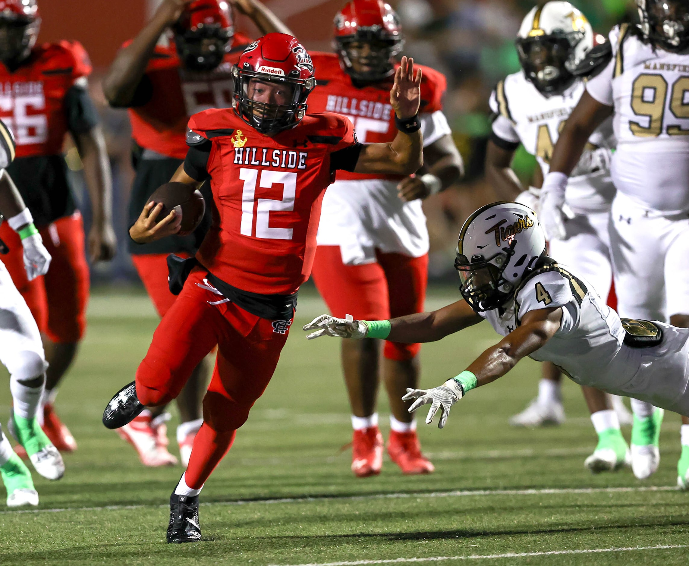 Cedar Hill quarterback Anthony Edwards (12) gets past Mansfield safety Dylan Thrash (4) for...