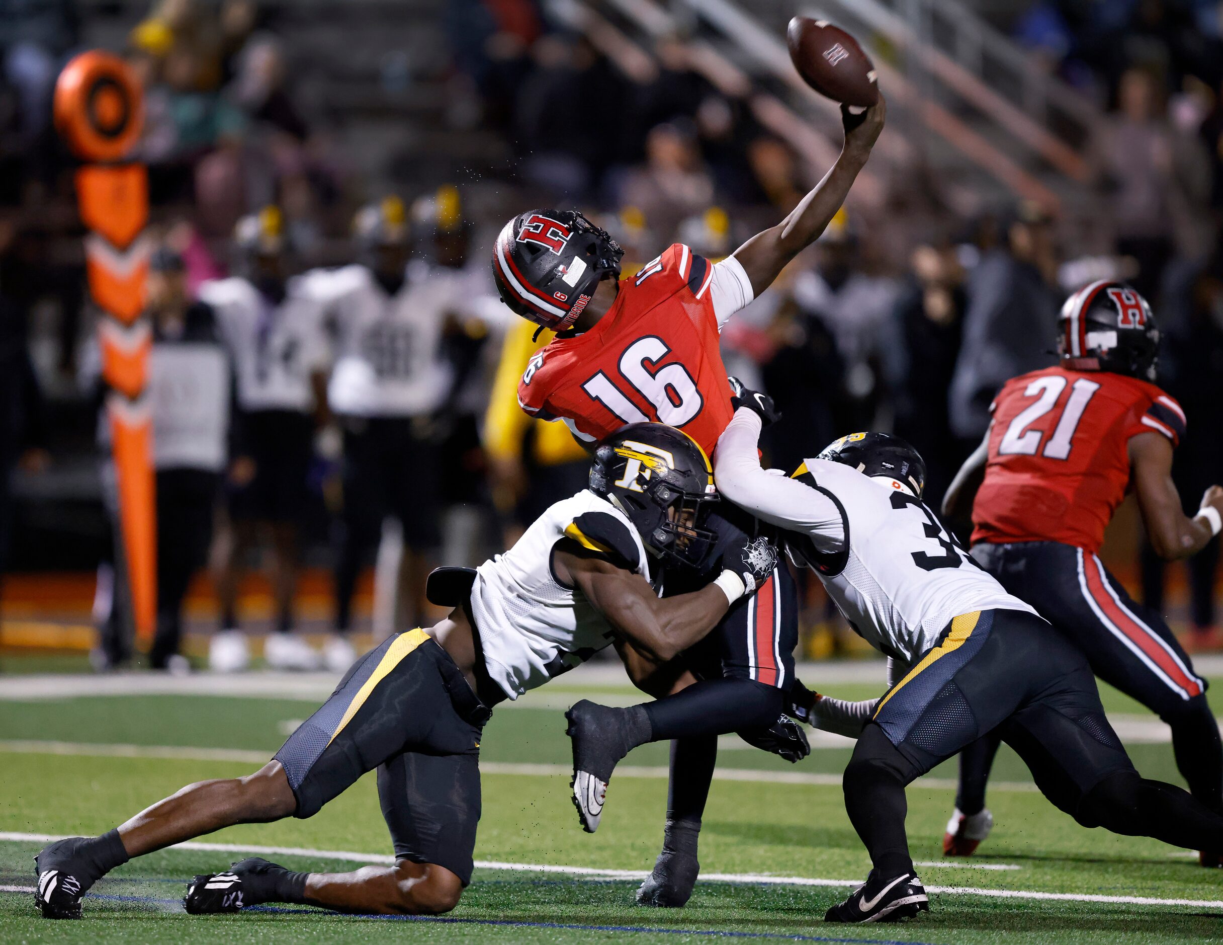 Rockwall-Heath quarterback Prosper Neal (16) is sandwiched by Forney defenders Orin Gee...