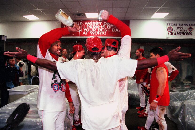 Texas Rangers players Darryl  Hamilton (with bottle) and Will Clark (with can) douse second ...
