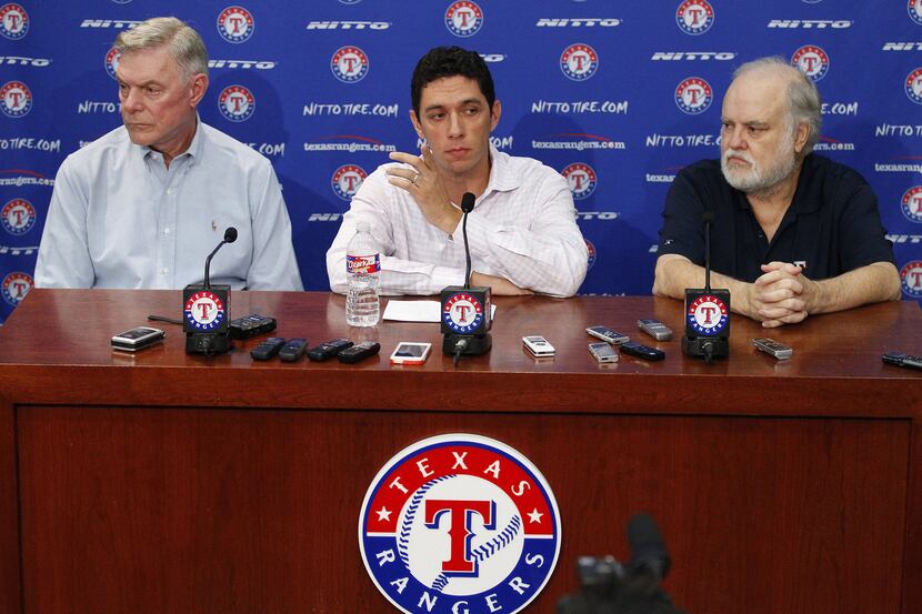 Texas Rangers owners Ray Davis, left, and Bob Simpson, right, flank President of Baseball...
