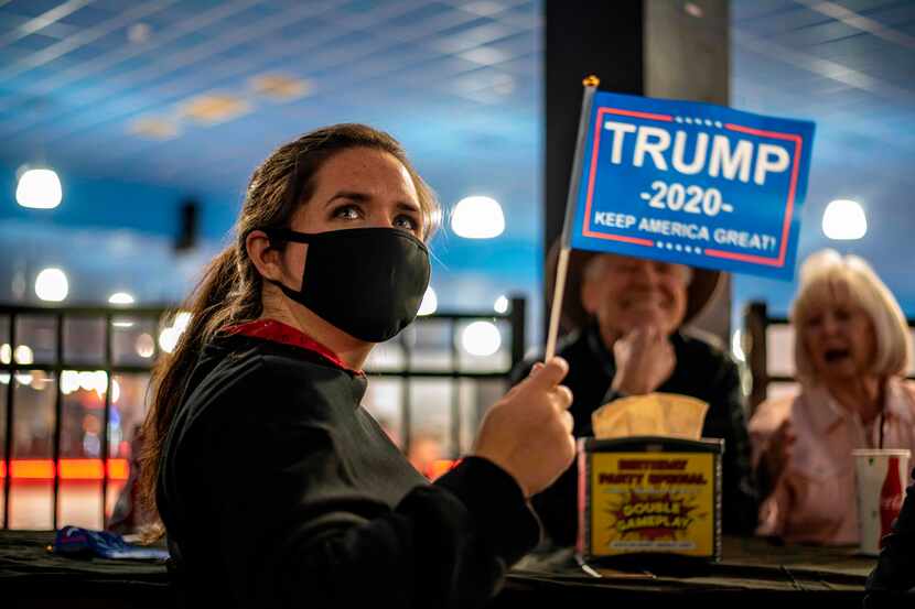 An attendee at a watch party for Republicans waves a Trump 2020 flag on election day,...