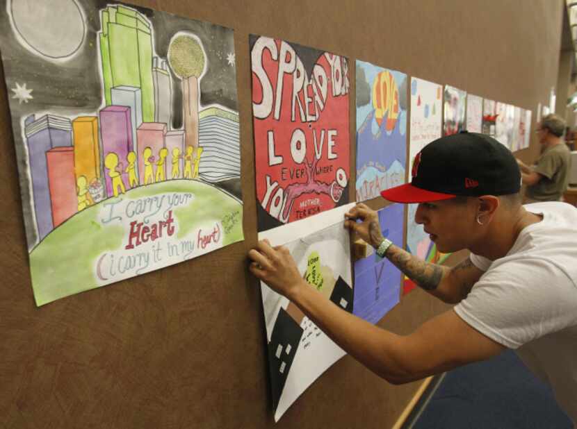 Volunteer Eduardo Morales of Dallas installs art pieces as part of the Dallas LOVE project...