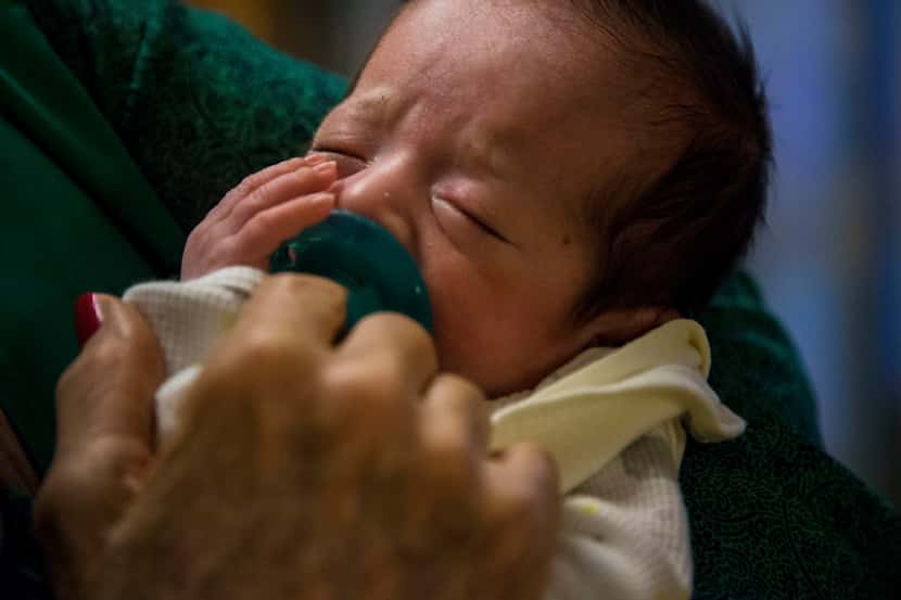 Volunteer Beverley Denman holds Abraham Gonzalez, who was born two months early on Oct. 16,...