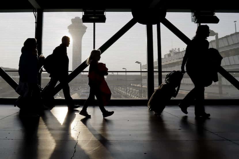 FILE - In this Dec. 1, 2013 file photo, travelers walk through terminal 3 at O'Hare...