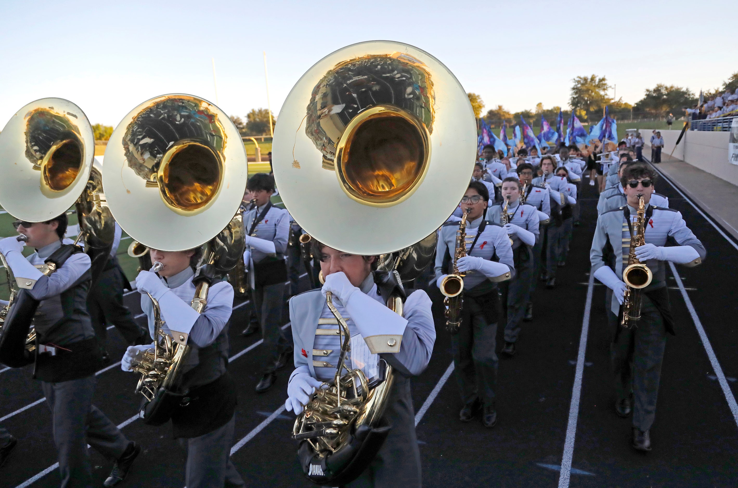 Plano East High School marching band member Christian Earls (center), plays the sousaphone...