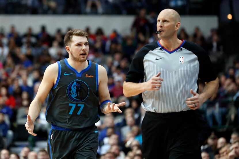 Dallas Mavericks' Luka Doncic (77) jogs up court talking with referee Eric Dalen, right,...