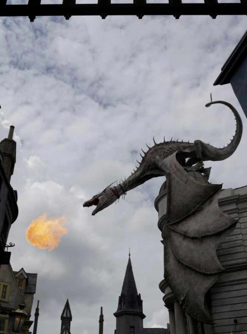 
A dragon breathes fire from atop Gringotts Bank at Diagon Alley at the Wizarding World of...