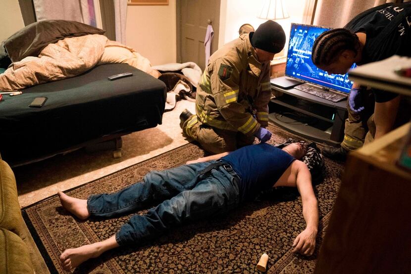 Firefighter Jim Terrero (right) and Corey Joy assess the condition of a 35-year-old man who...