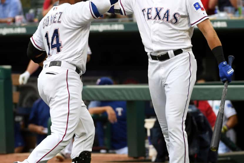 Texas Rangers' Carlos Gomez, left, is congratulated by Joey Gallo, right, after hitting a...