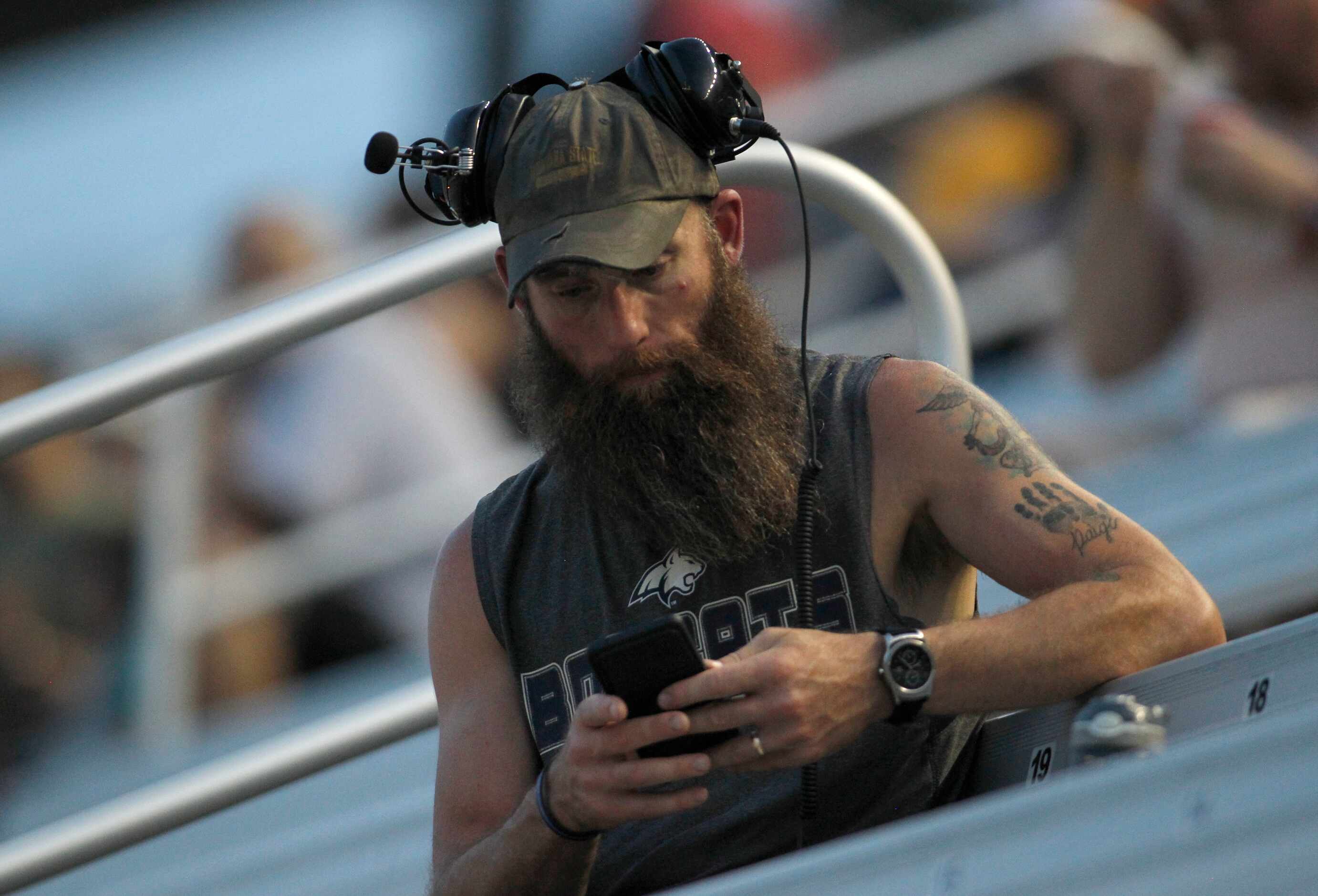 Race enthusiast Ross Krueger of Dallas takes a break to deliver a text during a caution...