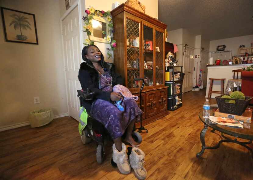 Mythia Joseph puts on warmer shoes as she sits in her motorized wheelchair, before venturing...
