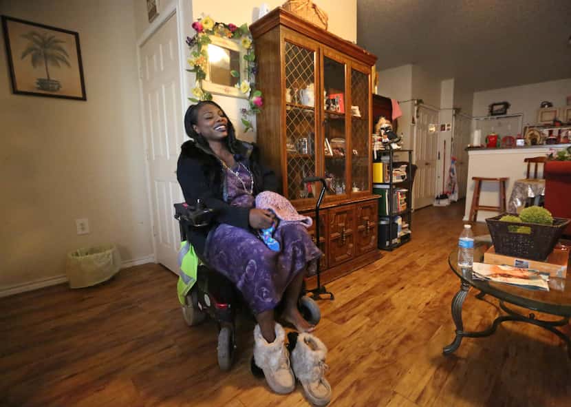 Mythia Joseph puts on warmer shoes as she sits in her motorized wheelchair, before venturing...