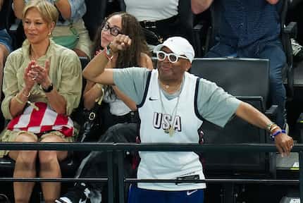 Film director Spike Lee cheers Simone Biles of the United States after she competed on the...
