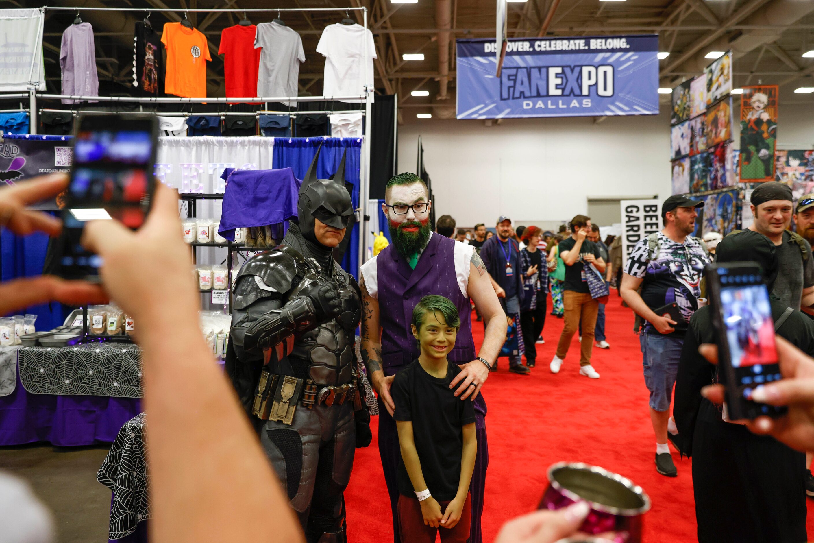 Will Ellis (left) dressed as Batman takes a photo with Jason Walter and his son Liam, 8,...