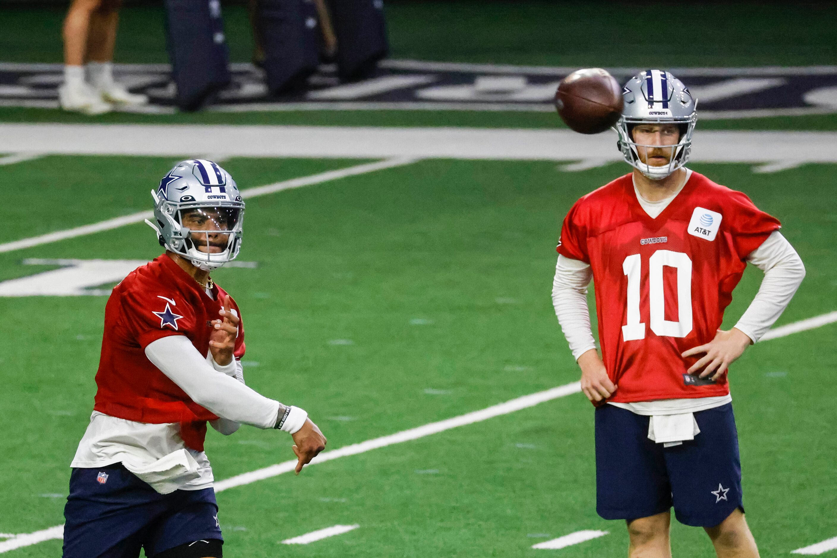 Dallas Cowboys quarterback Dak Prescott (left) throws the ball as quarterback Cooper Rush...