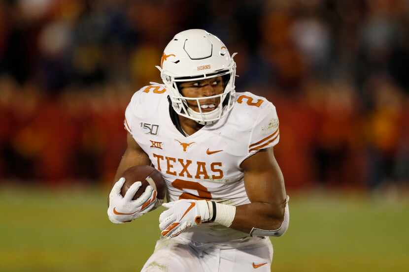 Texas running back Roschon Johnson carries the ball up field during the second half of an...