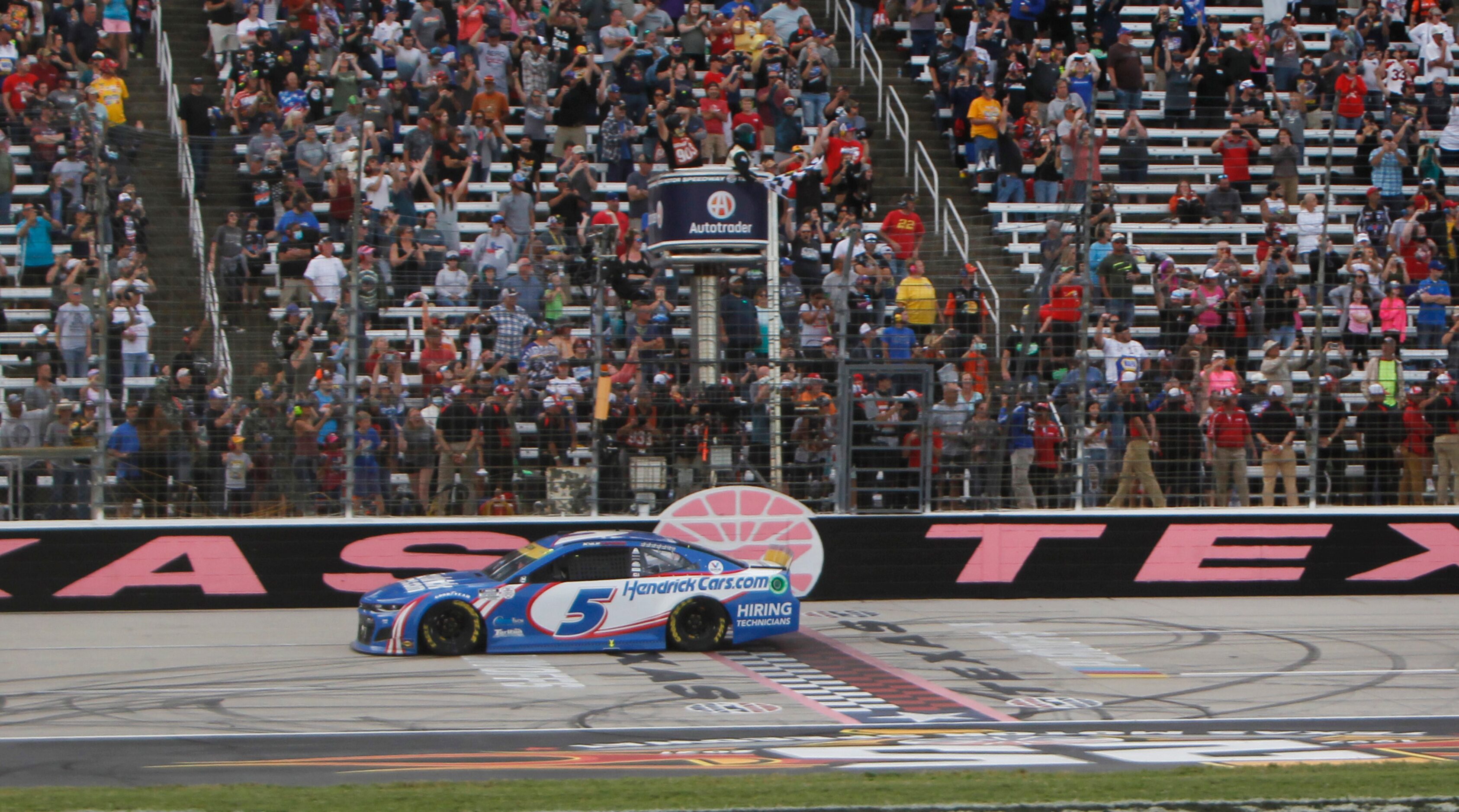 Kyle Larson receives an ovation from racing fans as he crossed the finish line to the...