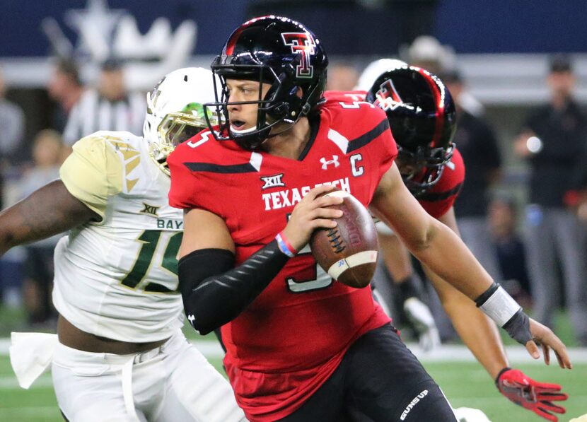 Texas Tech quarterback Patrick Mahomes II (5) rolls out to find a receiver in the first...